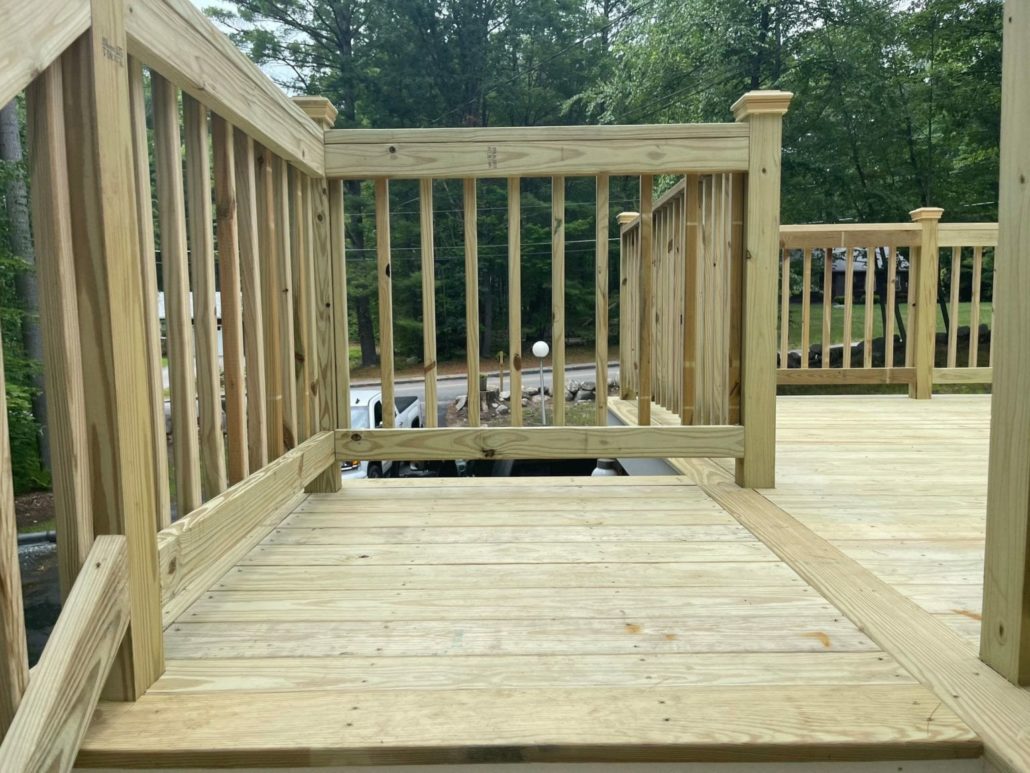 A close up of newly built pressure treated wood railings on a wooden deck.