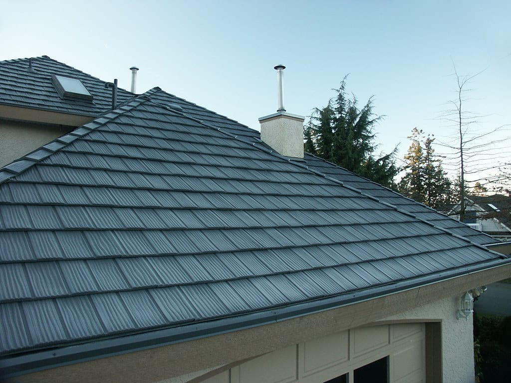 A garage with black metal shingle roofing.