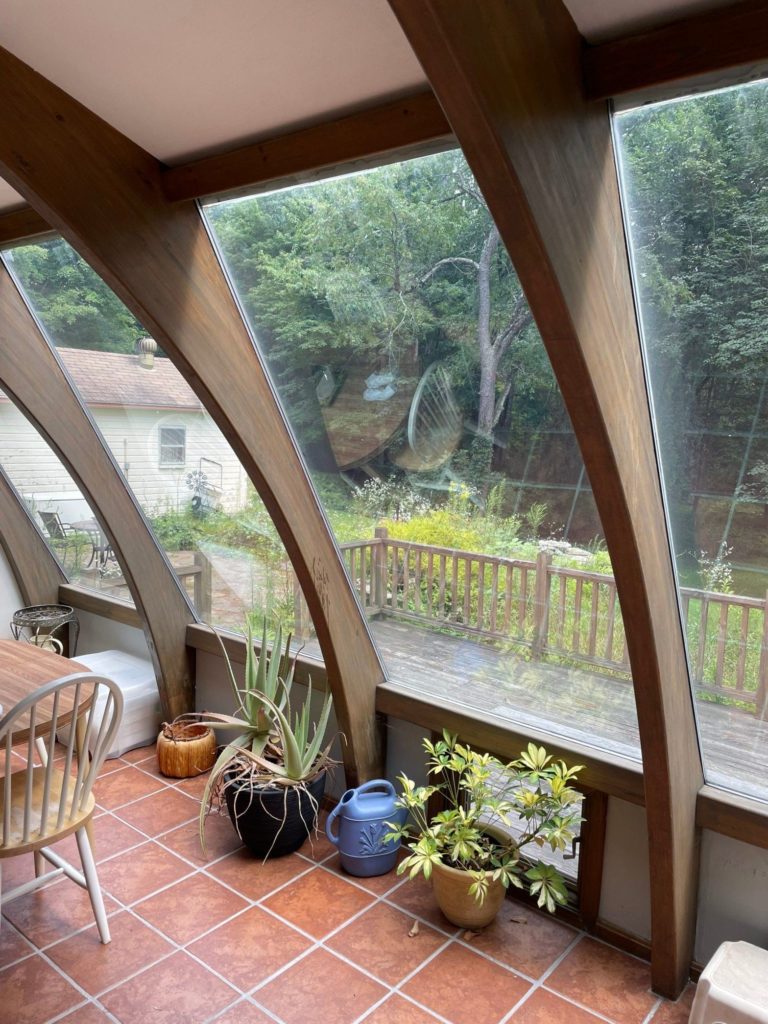 Curved windows looking out at deck in the backyard.