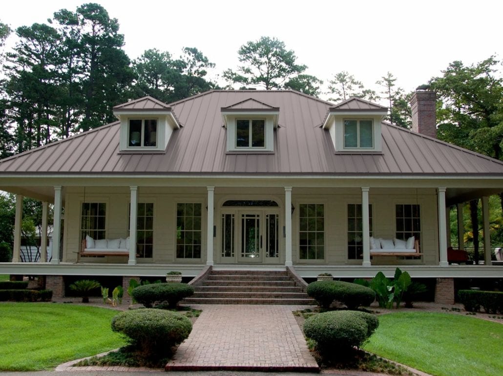 A 2 story home with white siding and an ash gray standing seam roof.