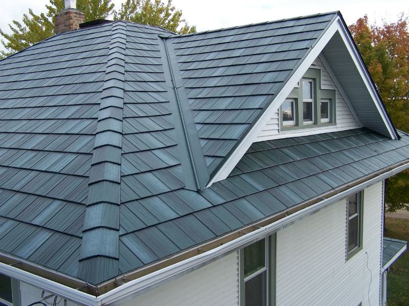 A white home with gray metal shingle roofing.