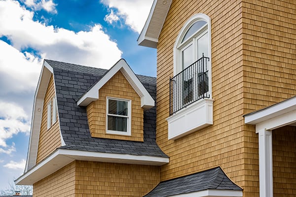 A home with tan Beach House shake siding with white trim.