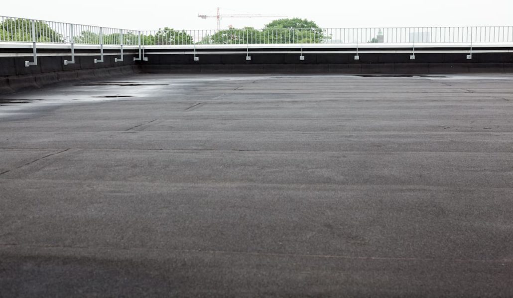 A flat commercial roof with fresh black roofing membrane.