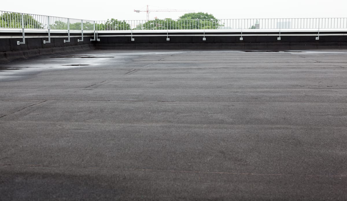 A flat commercial roof with fresh black roofing membrane.