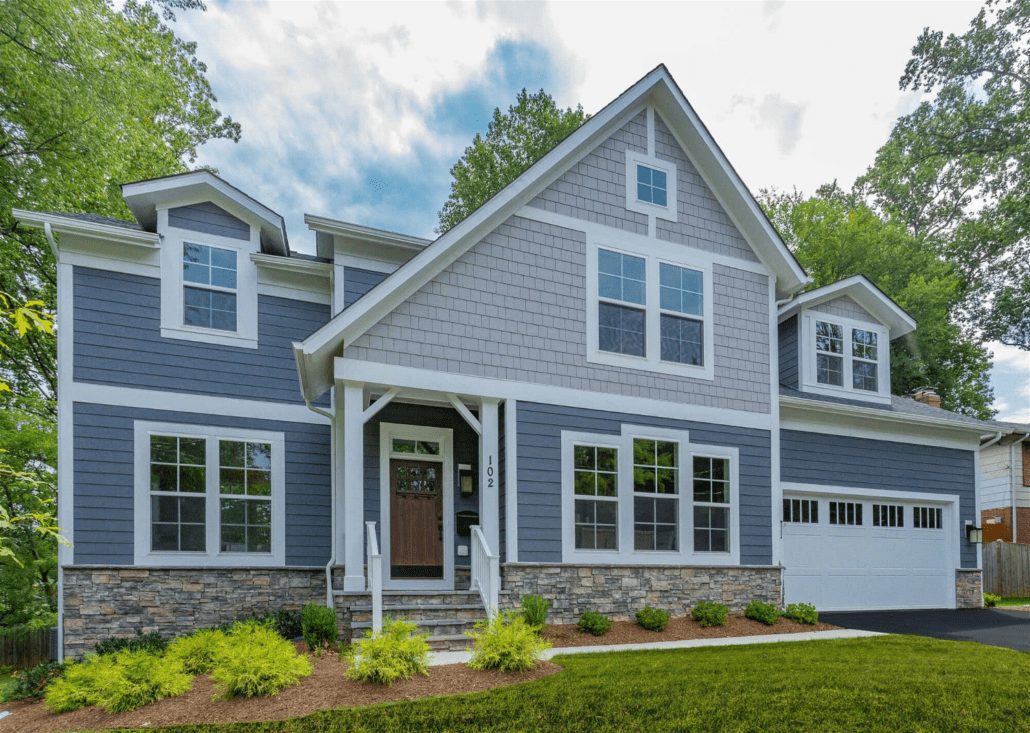 A 2 story home with blue gray JamesHardie clapboard and light gray shake siding with white trim.
