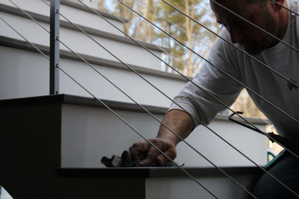 A man building a wood deck on a Durham, NH home.