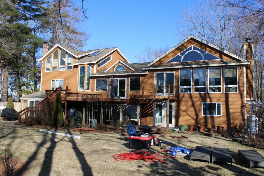 A man building a composite deck on a home in Hampstead, NH.