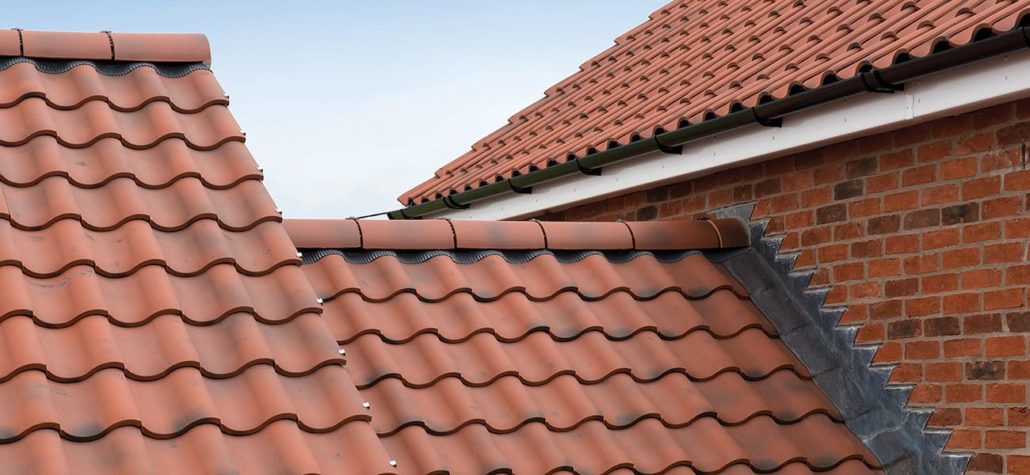 Red metal clay tiles on a brick home.