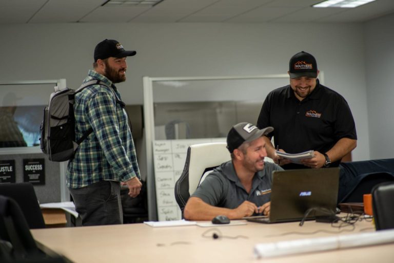 Three men laughing in an office in Dover, NH.