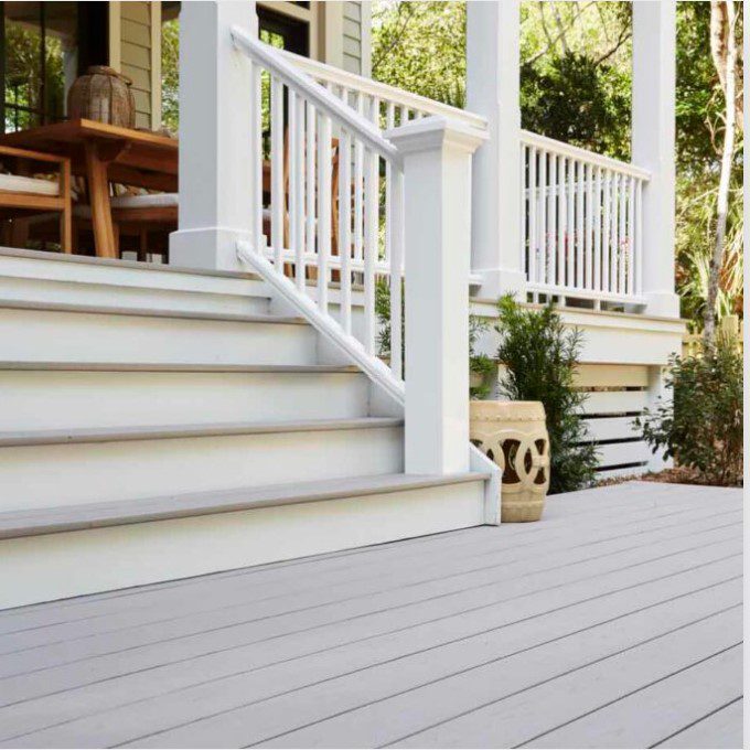 Gray composite decking and stairs with white trim and railings and hidden decking fasteners.