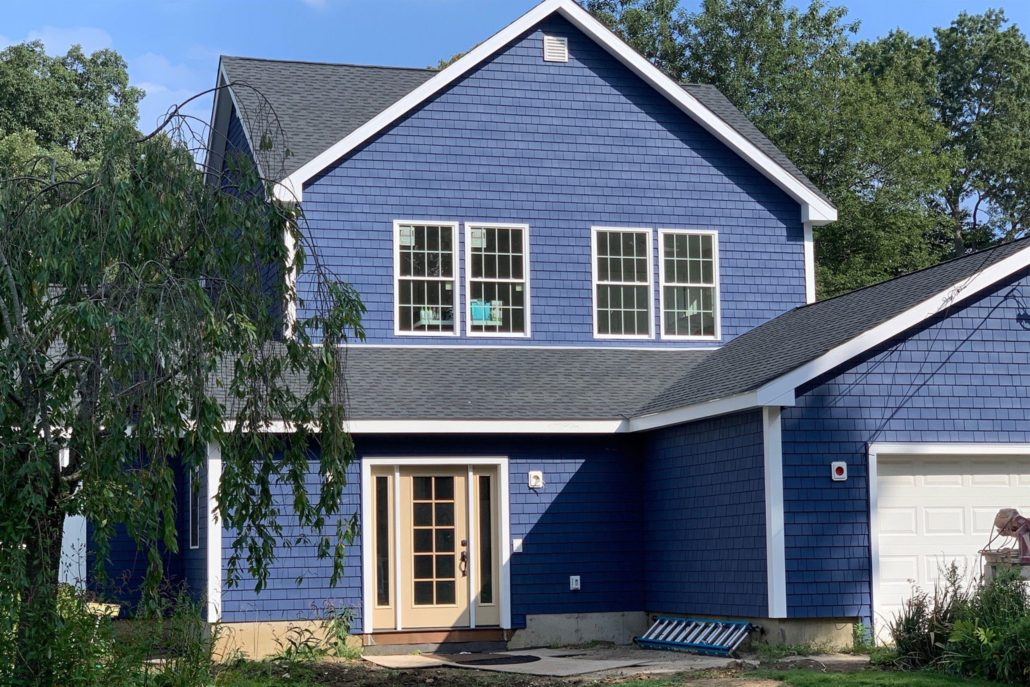 The backside of a 2 story home with blue Tando Cape Cod Perfections shake siding.