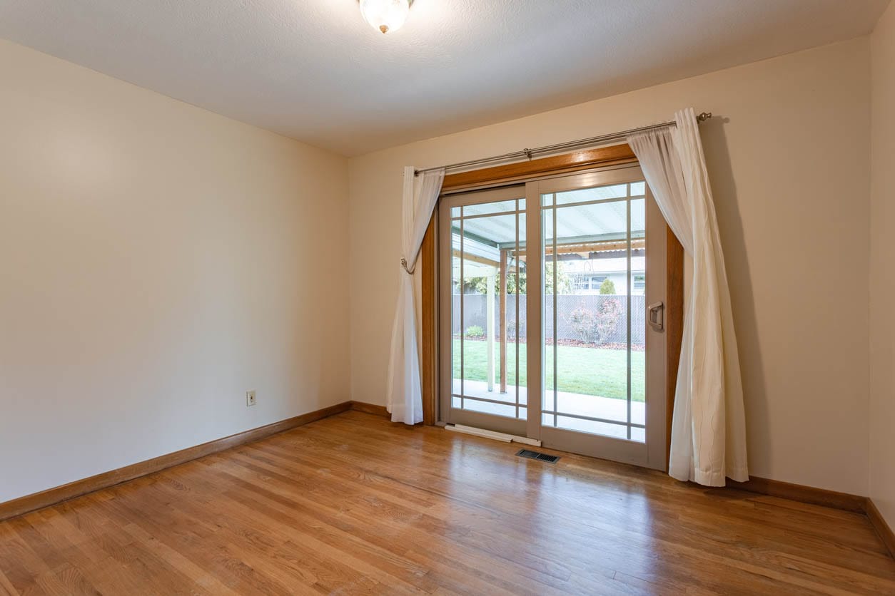 Sliding patio doors inside a home leading to a backyard.