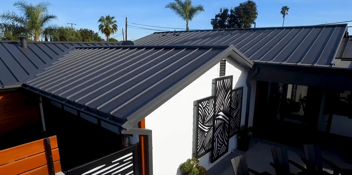 A white home with black standing seam metal roofing.