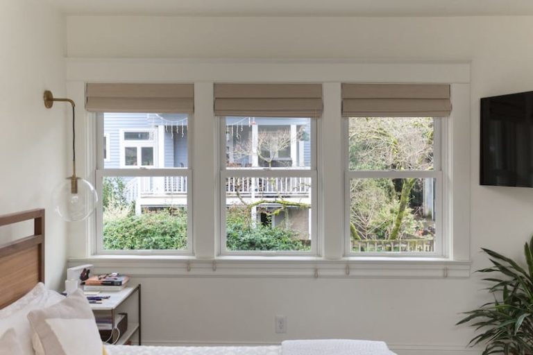Three windows with the blinds open from the interior of the home.
