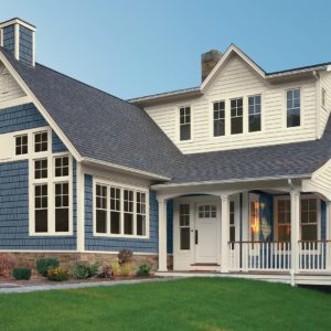 A home with blue shake siding and white Royal clapboard siding.