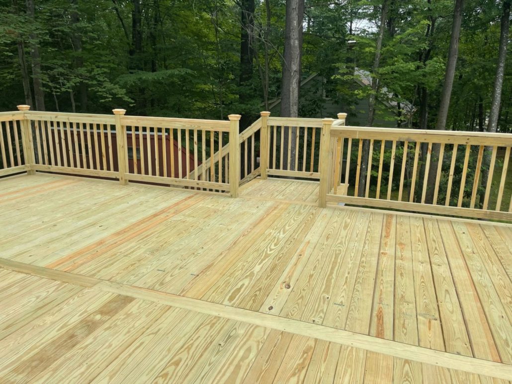 A newly built pressure treated wood deck, railings, and stairs.