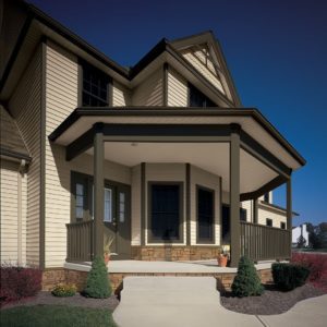 A home with light beige Royal siding and dark brown trim and railings