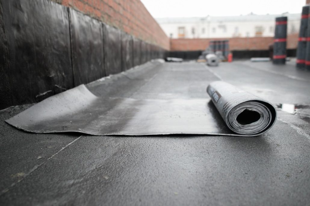 A roll of EPDM membrane on a flat commercial roof.