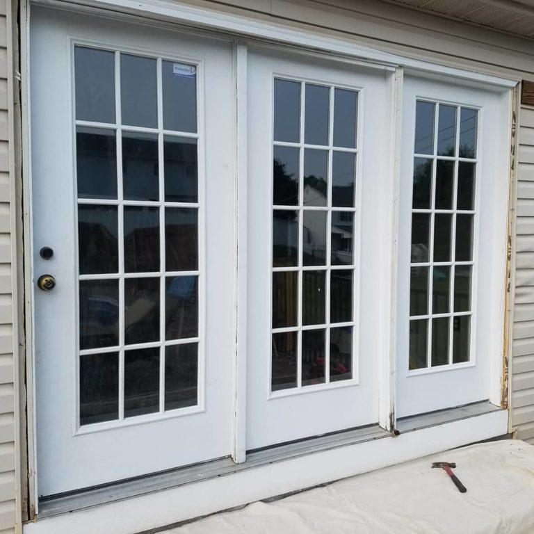 White hinged patio doors with full length glass panes.