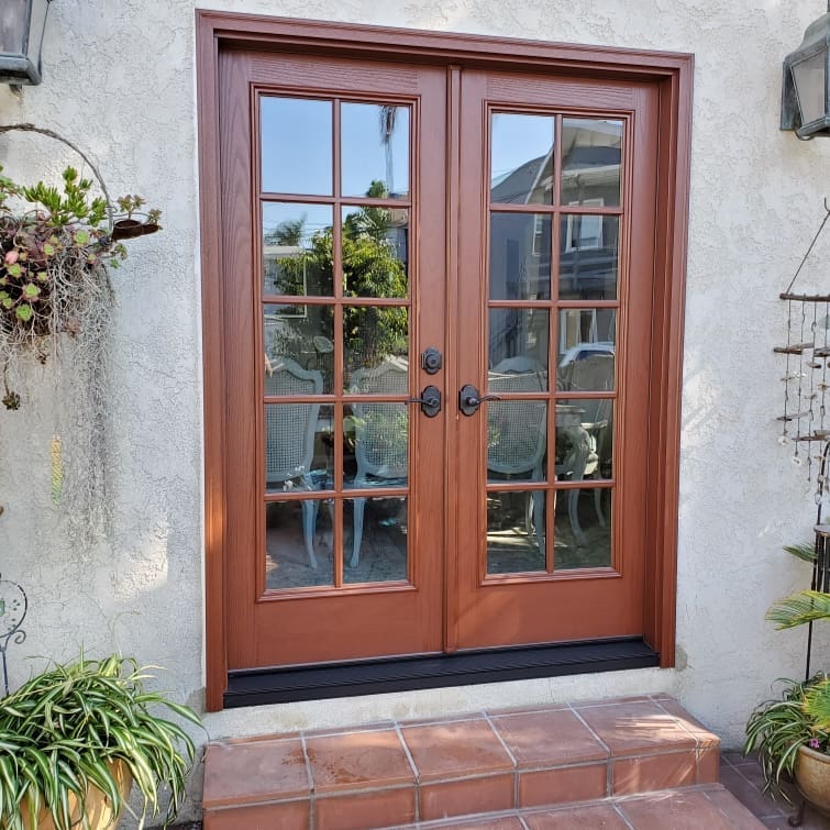 Double wood hinged patio doors with glass panes.