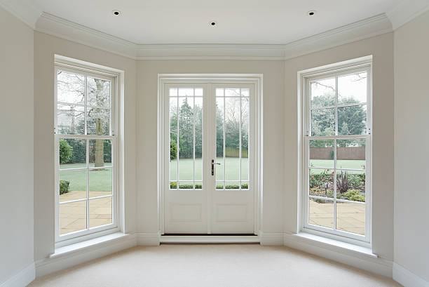White full length windows with an entry door in the middle from the interior of the home.