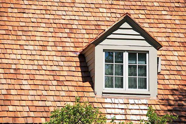 Dormer in the roof of house with cedar shake shingles.