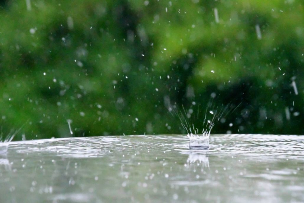 Rain drops splashing into a puddle.