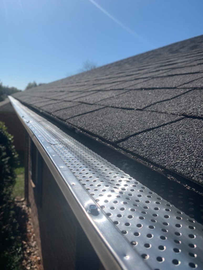 A home's gutters that are covered by a metal gutter guard.