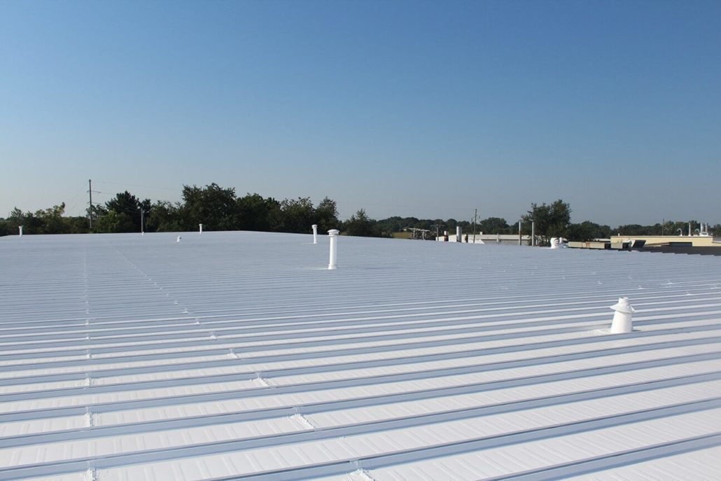 A commercial roof with freshly applied white silicone roof coating.
