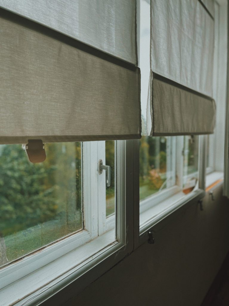 Windows with blinds pulled down over most of the glass from the interior of the home.