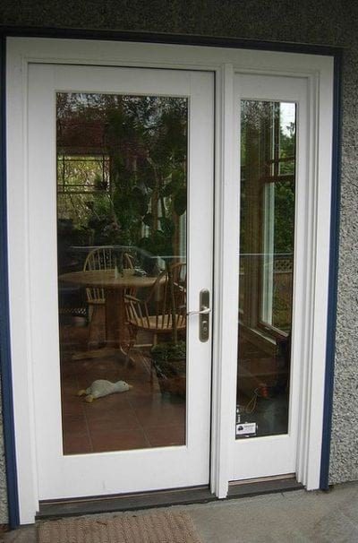 A glass hinged patio door with white trim.
