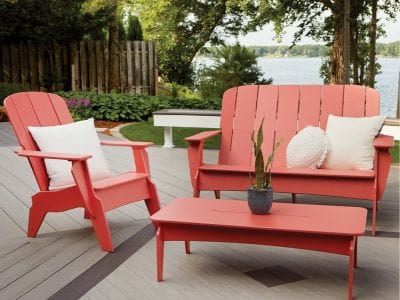 A tan and brown composite deck with hidden fasteners and a red coffee table with matching chairs.