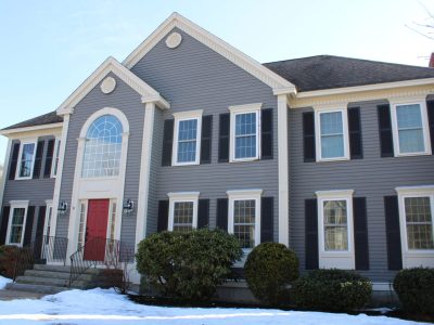 A large 2 story home in Hampton, NH with gray siding and a black asphalt shingle roof.