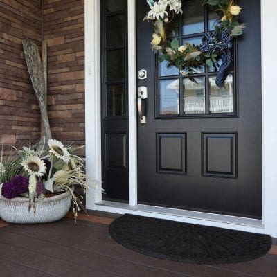 A home with a black exterior door and brown TandoStone composite siding.