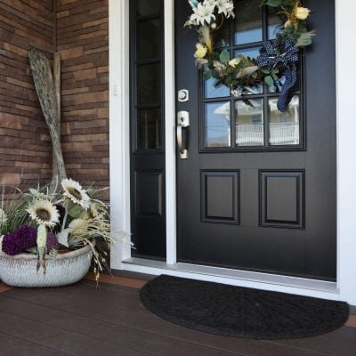 A home with a black exterior door and brown TandoStone composite siding.