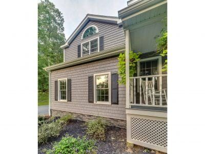 A home with beige TandoShake siding and brown shutters.