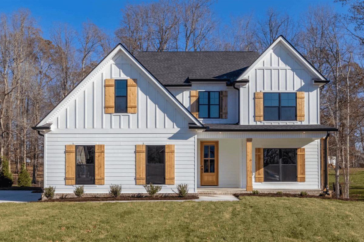 A 2 story home with white JamesHardie clapboard and board & batten siding and wood shutters.