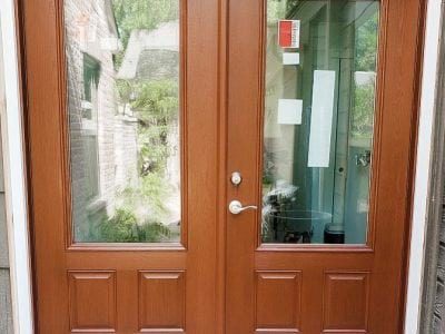 Double wood hinged patio doors with glass windows.