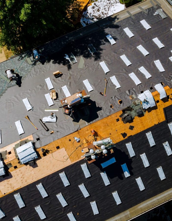 An overview of workers completing an asphalt shingle roofing replacement.