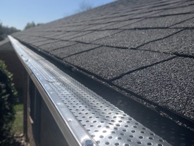 A home's gutters that are covered by a metal gutter guard.